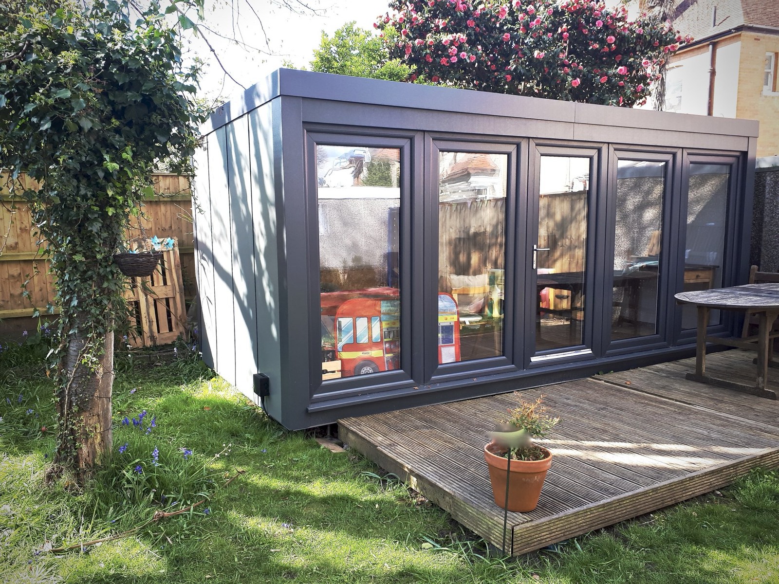 Booths garden room with bifold-style glazing in a garden