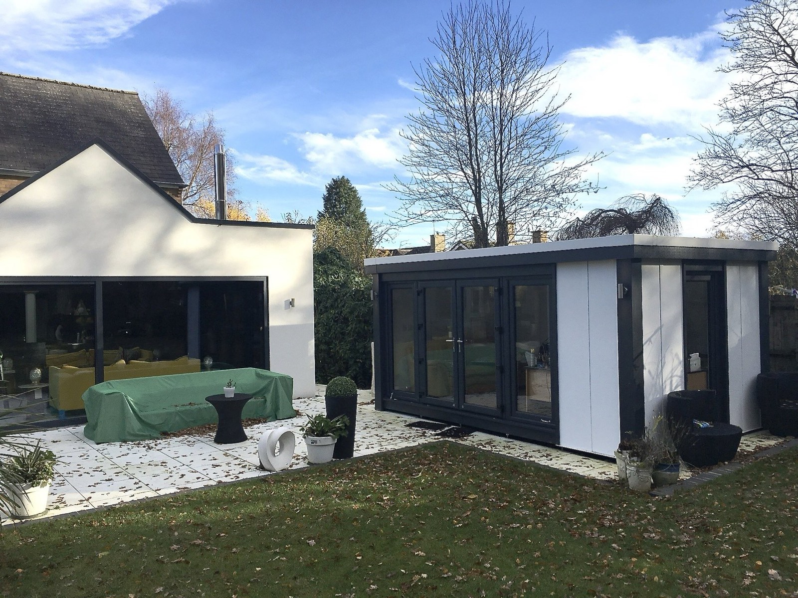 White and anthracite Booths garden room under a blue sky
