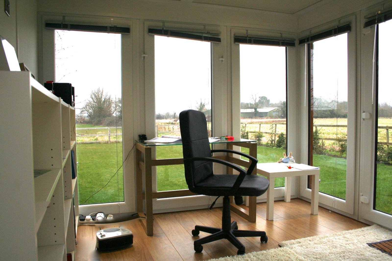 Inside a Booths garden office — desk and chair overlooking countryside