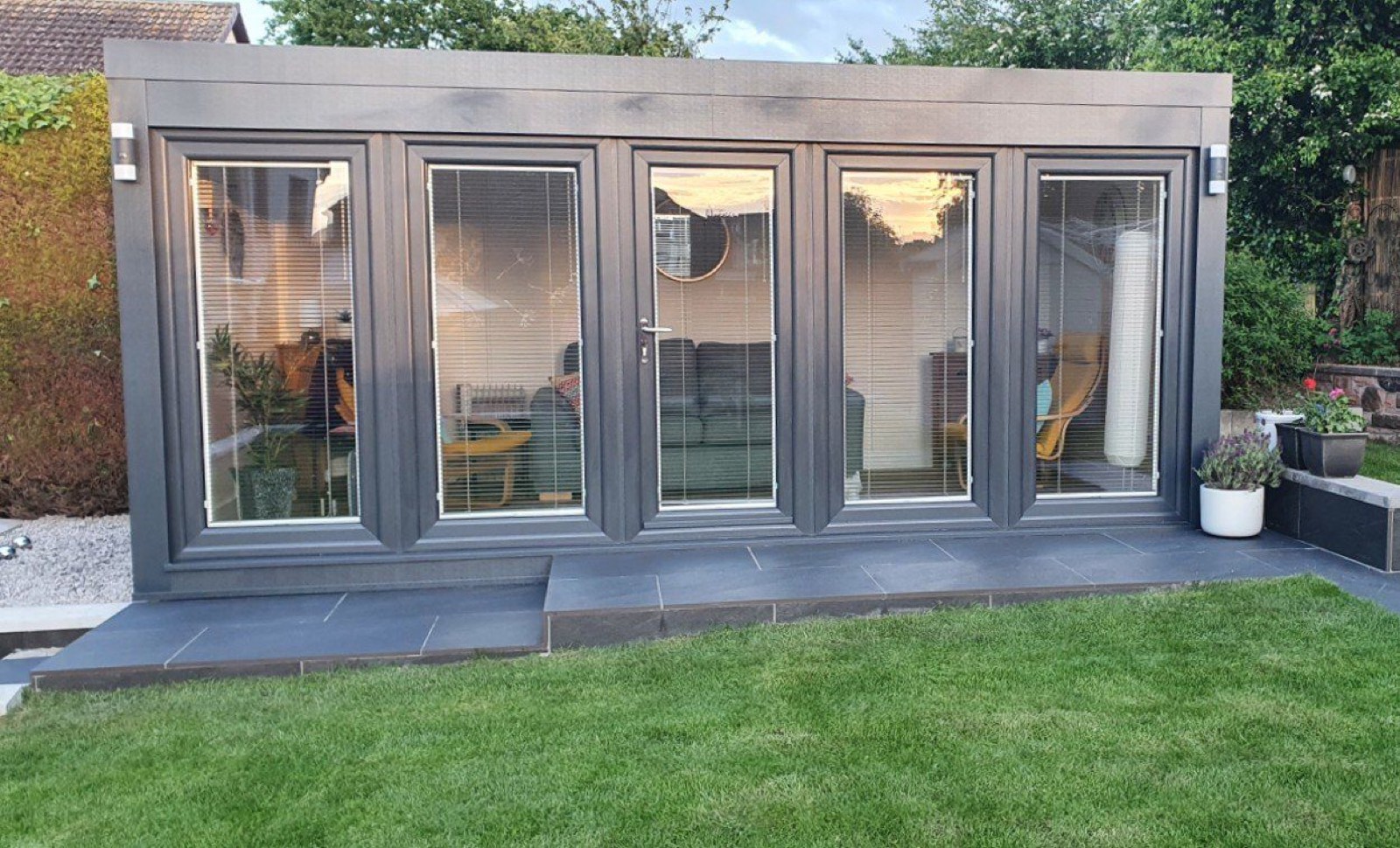Anthracite Booths QCB garden office at dusk on a Scottish slate patio